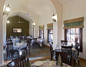 un comedor con mesas y sillas en un restaurante en MANVĀR SHERGARH, THE DESERT RESORT, en Shaitrāwa