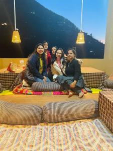 a group of people sitting on a couch at Pyare Cafe Cottages And Tents in Gushaini