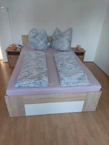 Una cama con sábanas y almohadas moradas. en schönes Ferienhaus mit grossem Pool 1200 m zum Balaton, en Balatonberény