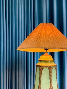 a lamp on a table in front of a blue curtain at Zen Villa - Retreat Homestay in Bắc Ninh