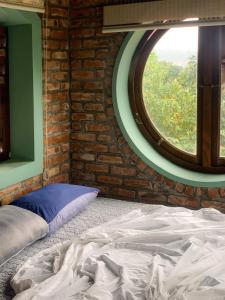 a bed in a room with a round window at Zen Villa - Retreat Homestay in Bắc Ninh