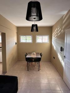uma sala de jantar com uma mesa e cadeiras sob um lustre em Apartamento Céntrico para 4 personas con Patio em Santiago del Estero