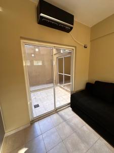 sala de estar con sofá y ventana en Apartamento Céntrico para 4 personas con Patio en Santiago del Estero