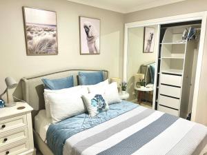a bedroom with a bed with blue and white pillows at Guest house in Harrington Park in Narellan