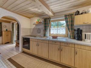een keuken met houten kasten, een wastafel en een raam bij Holiday home Sterl in Eppenschlag