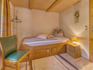 een kleine slaapkamer met een bed en een stoel bij Holiday home Sterl in Eppenschlag