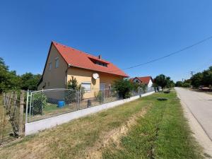 ein Haus an der Seite einer Straße mit einem Zaun in der Unterkunft schönes Ferienhaus mit grossem Pool 1200 m zum Balaton in Balatonberény