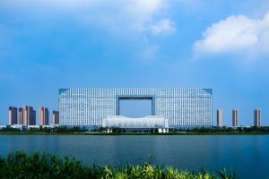 een groot gebouw naast een grote hoeveelheid water bij Suzhou International Conference Hotel in Suzhou