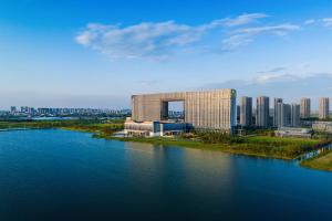 een groot gebouw naast een waterlichaam bij Suzhou International Conference Hotel in Suzhou