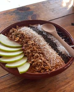 un tazón de granola y manzanas sobre una mesa de madera en Porã Chacahua en Guayabas