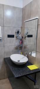 a bathroom with a white sink and a mirror at Crop and Food Home Stay in Vallikunnu