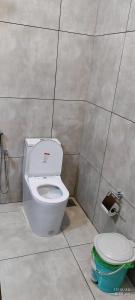 a bathroom with a toilet and a roll of toilet paper at Crop and Food Home Stay in Vallikunnu