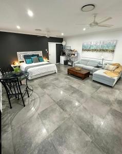 a large living room with two beds and a couch at Large Studio in the heart of Hope Island & Sanctuary Cove in Gold Coast