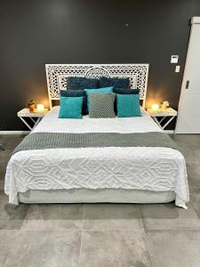 a bedroom with a large bed with blue pillows at Large Studio in the heart of Hope Island & Sanctuary Cove in Gold Coast
