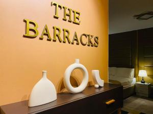 a bedroom with a sign that reads the barriers and vases at The Barracks Staycation in Santa Rosa