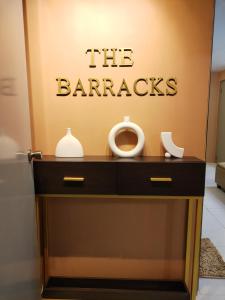 uma cómoda com um sinal que lê as barreiras em The Barracks Staycation em Santa Rosa