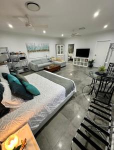 a bedroom with a large bed and a living room at Large Studio in the heart of Hope Island & Sanctuary Cove in Gold Coast