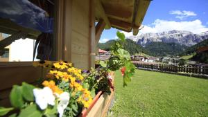 a balcony with flowers on the side of a building at Residence Villa al Sole in Selva di Val Gardena