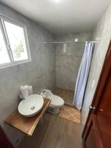 uma casa de banho com um WC, um lavatório e um chuveiro em Casa del Mar Malin em Ballenita