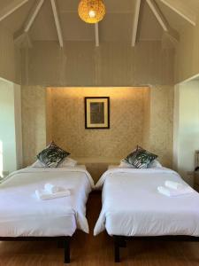 duas camas num quarto com lençóis brancos em Katiliya Park Villa em Mae Chan