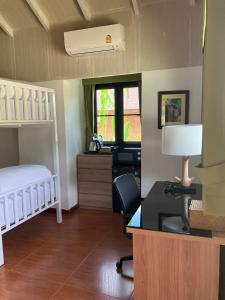 uma sala com um quarto com uma secretária e uma cama em Katiliya Park Villa em Mae Chan