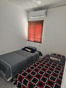- une petite chambre avec 2 lits et une fenêtre dans l'établissement Rivera Casa mía, à San Miguel