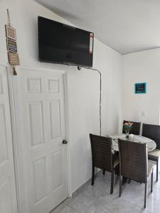um quarto com uma mesa e uma televisão na parede em Rivera Casa mía em San Miguel