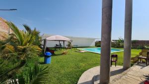 a backyard with a pool and a gazebo at Jardines de Milé in Laredo Hacienda
