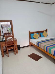 1 dormitorio con cama, espejo y mesa en River Paradise en Kalutara