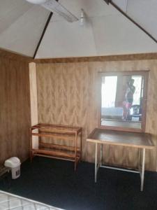 Cette chambre dispose d'une table en bois et d'une fenêtre. dans l'établissement River Paradise, à Kalutara