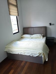 una camera da letto con un letto con lenzuola bianche e una finestra di 18 My home a Nusajaya