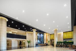 a lobby of a shopping mall with a large building at Newyantai Hotel Hainan in Haikou