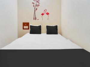 ein Schlafzimmer mit einem Bett mit zwei Flamingos an der Wand in der Unterkunft OYO Classic Grand Residency in Puducherry