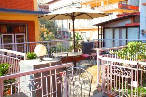 a patio with an umbrella and tables and chairs at Hotel Atlantic in Kathmandu