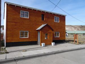 una pequeña casa de madera al lado de una calle en Doña Maria en Copahue
