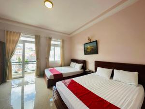 una camera d'albergo con due letti e una finestra di Duy Khang Hotel a Da Lat
