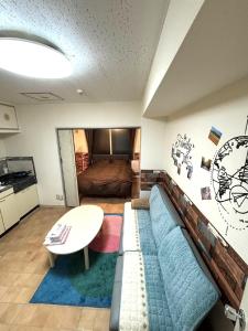 a living room with a couch and a bed at E-Horizon北2条 in Sapporo