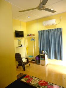 Cette chambre comprend un lit, une chaise et une fenêtre. dans l'établissement D'pinggir Guest Room, à Kuala Tahan