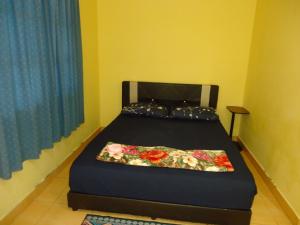 Un dormitorio con una cama con flores. en D'pinggir Guest Room, en Kuala Tahan