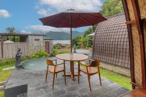 - une table et des chaises avec un parasol sur la terrasse dans l'établissement Cabana Bali Villa, à Kintamani