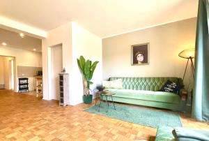 a living room with a green couch and a plant at Femo - Royal Siegen - königliche Wohnung - separater Eingang - Oberstadt nähe Marienkrankenhaus in Siegen