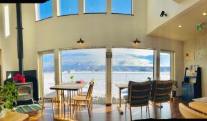 a dining room with a table and chairs and windows at Shooting Star the Bed & Breakfast in Furano