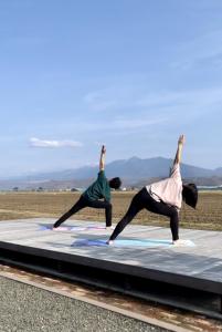 two people doing a yoga pose on a mattress at Shooting Star the Bed & Breakfast in Furano