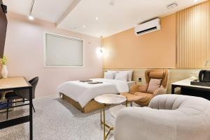 仁川的住宿－Brown Dot Hotel Incheon Jakjeon，酒店客房配有一张床、一张沙发和椅子。