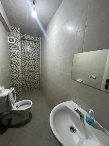 uma casa de banho com um lavatório branco e um WC. em Trigo em Safi