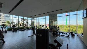 a gym with cardio equipment in a building with windows at Cosy home in heart of Colombo at Capitol Twinpeaks. in Colombo