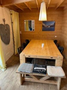 una mesa de madera en una habitación con guitarra en Beautiful *** Chalet Le Gentiane in L'Alpe du Grand Serre, en La Morte