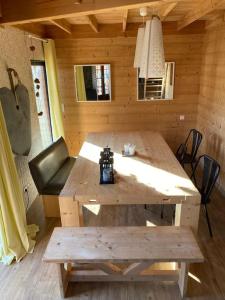 Cabaña de madera con mesa de madera y banco en Beautiful *** Chalet Le Gentiane in L'Alpe du Grand Serre en La Morte