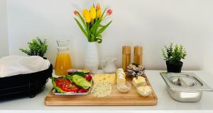 una tavola con un tagliere contenente verdure e formaggio di Apartament Sweet Time a Huta Szklana Altre 21 foto