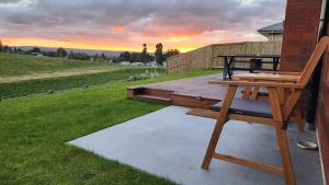 una terraza de madera con un banco en el lateral de una casa en A stunning retreat in Rotorua!, en Rotorua